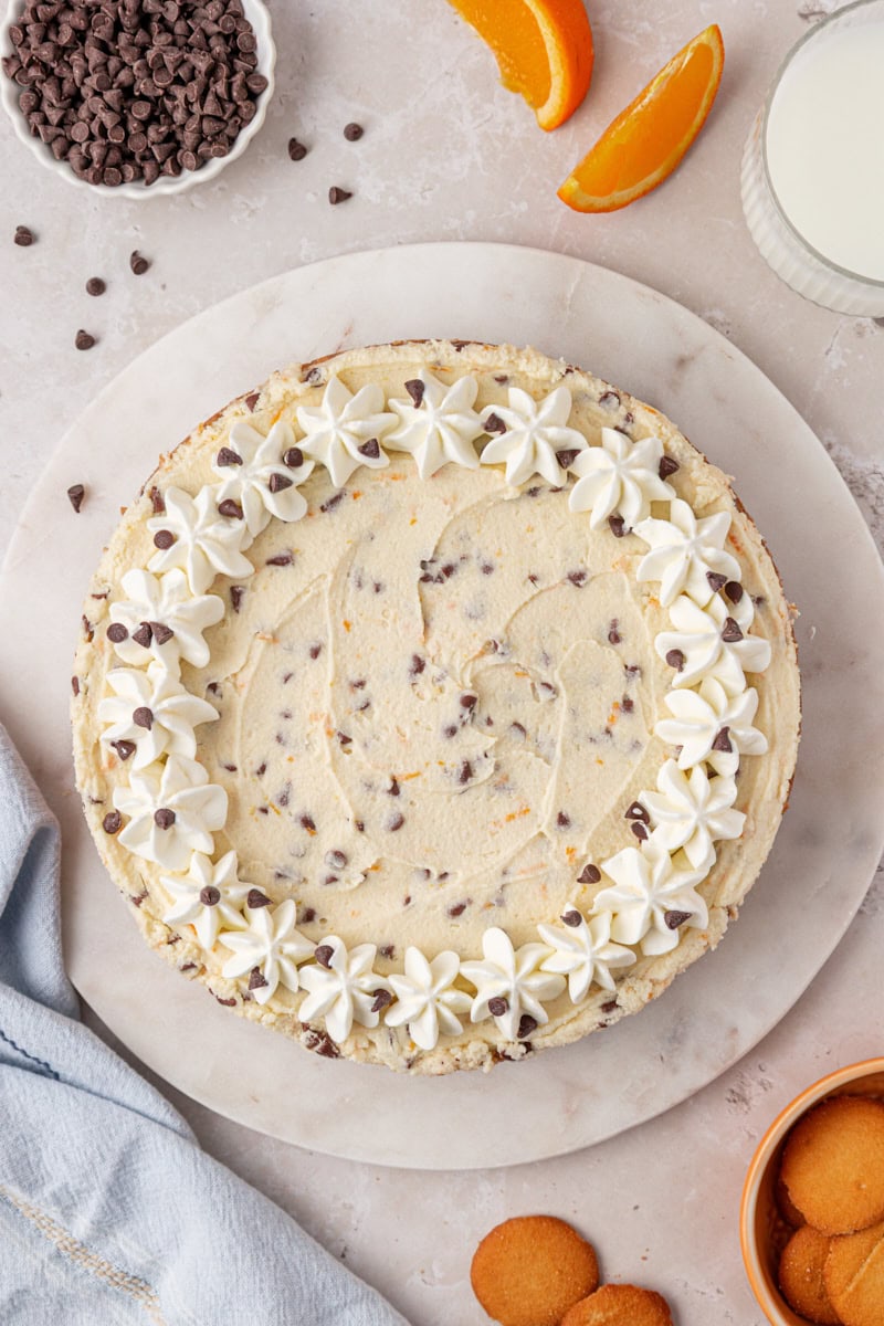 overhead view of chilled cannoli cheesecake garnished with whipped cream and mini chocolate chips