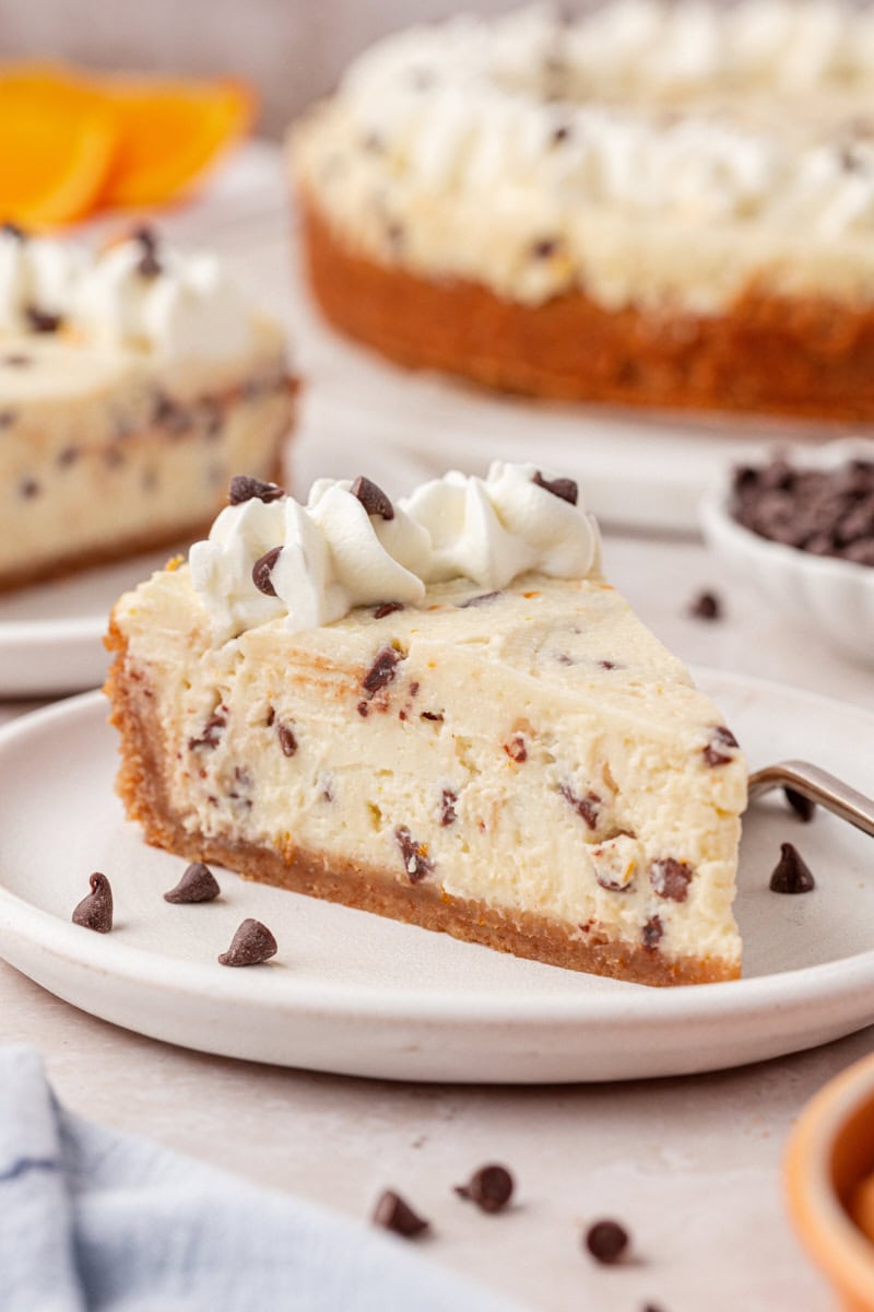 a slice of no-bake cannoli cheesecake filled with mini chocolate chips and orange zest
