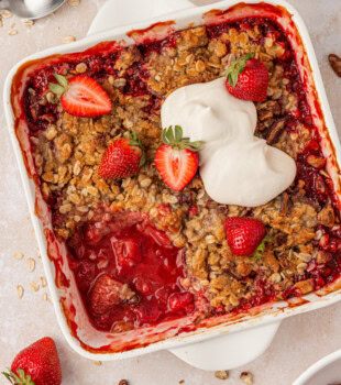 fresh strawberry crisp in a baking dish with a scoopful removed