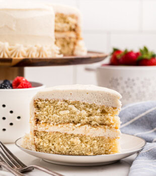 slice of soft vanilla layer cake topped with fluffy vanilla buttercream frosting