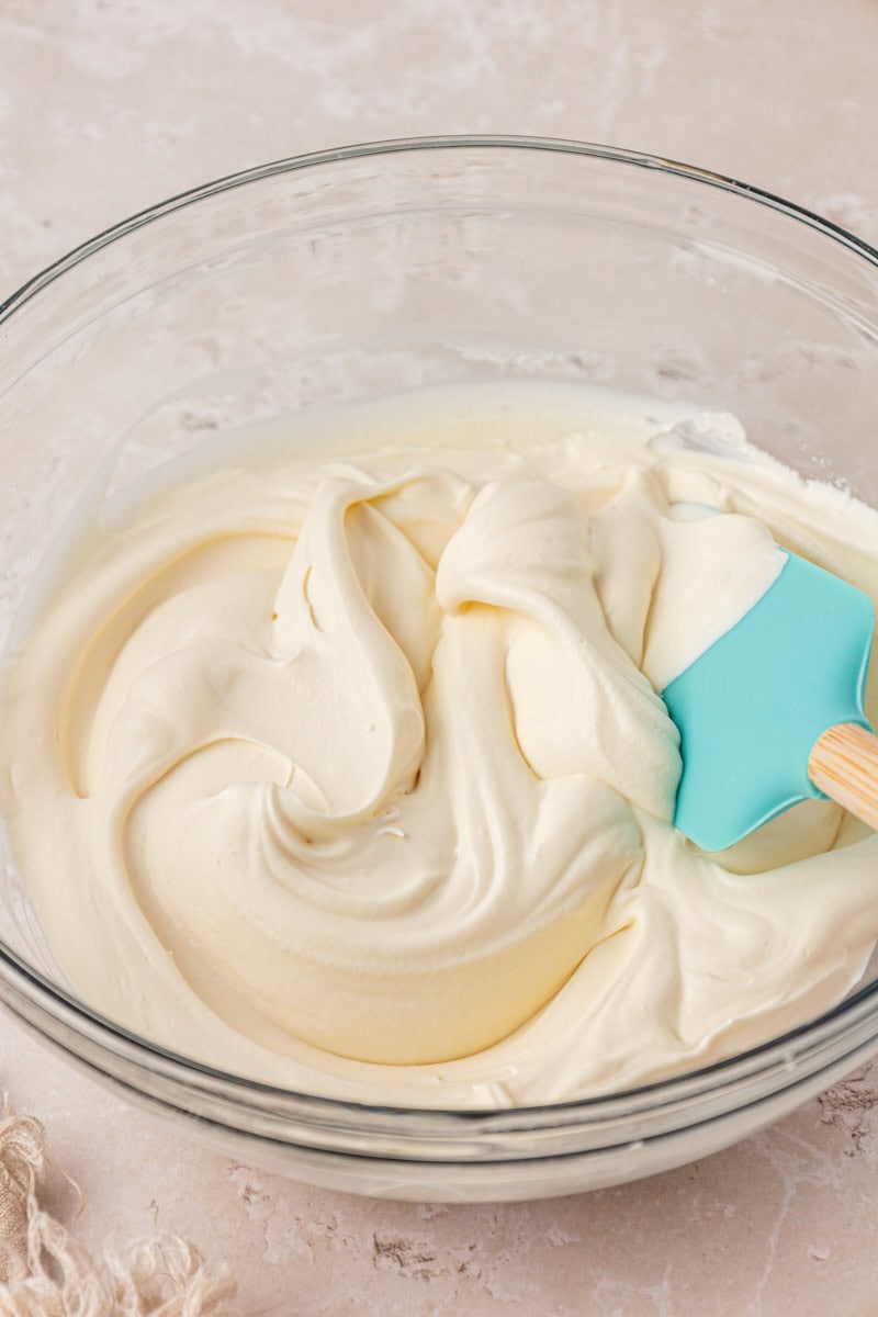 mascarpone whipped cream in a mixing bowl with a rubber spatula