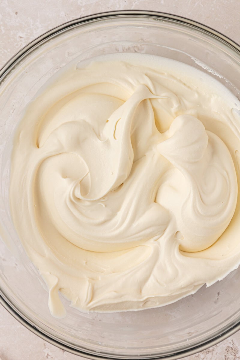 closeup view of soft, creamy mascarpone whipped cream in a glass bowl