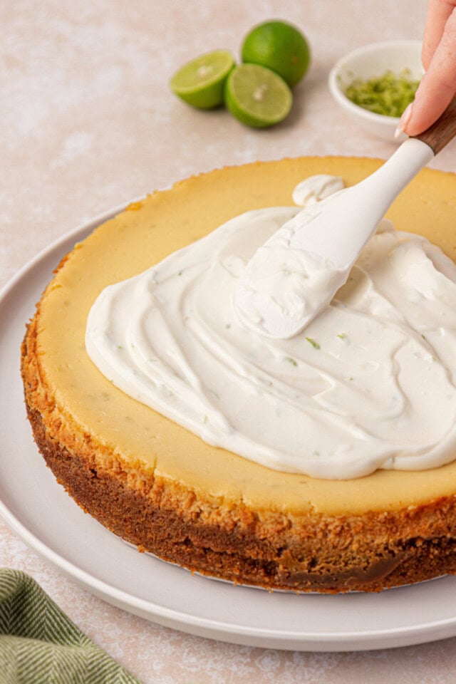 sour cream topping being spread over chilled Key lime cheesecake