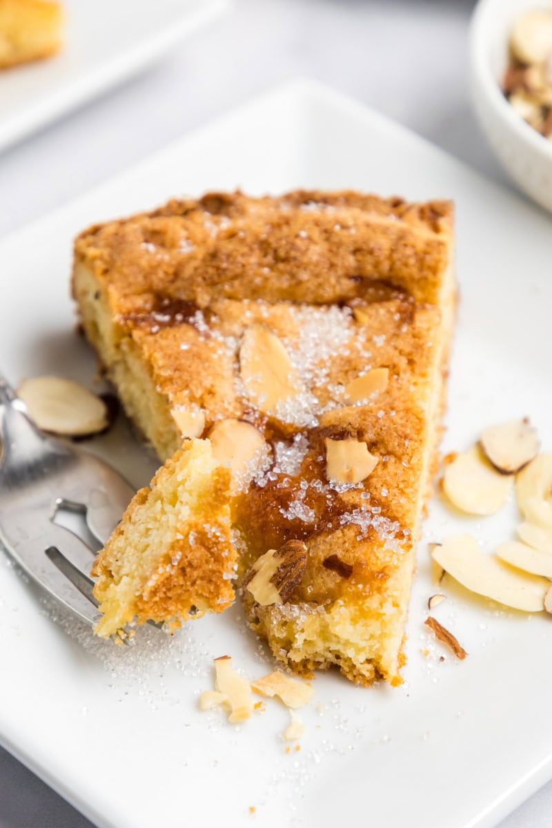 a slice of lemon almond butter cake on a plate with a bite on a fork