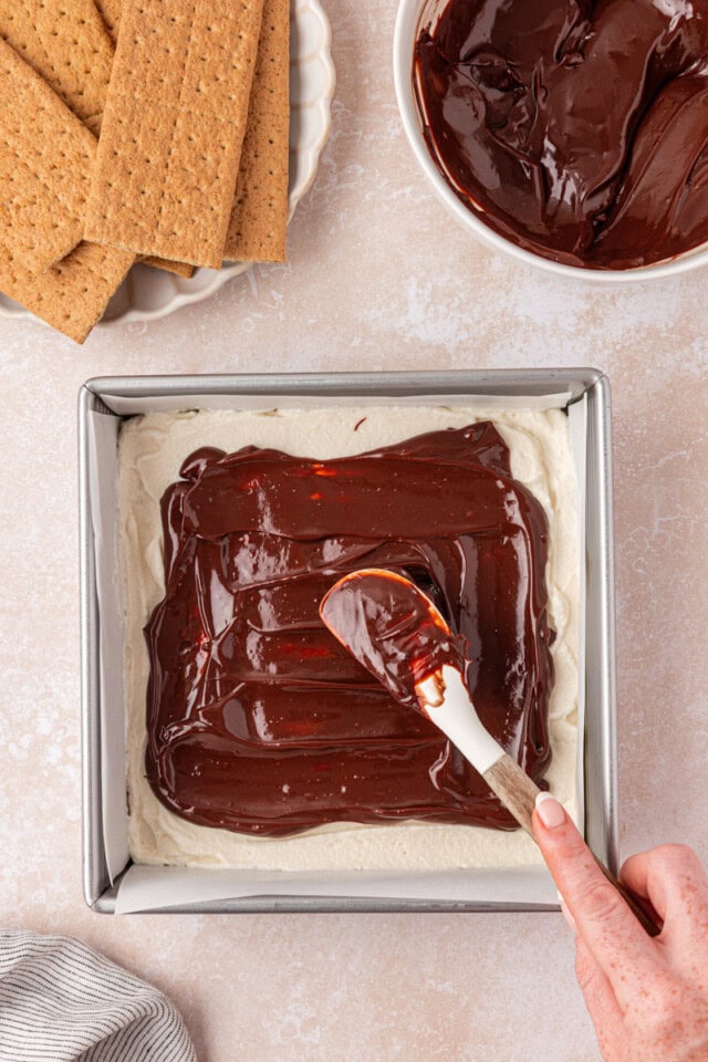 overhead view of chocolate ganache being spread over marshmallow filling