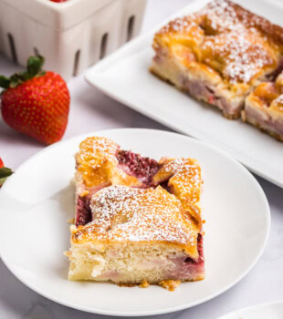 strawberry cheesecake cobbler served with a dusting of powdered sugar on top