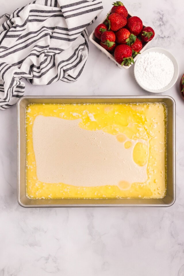 overhead view of milk mixture added to melted butter in a 9x13 pan