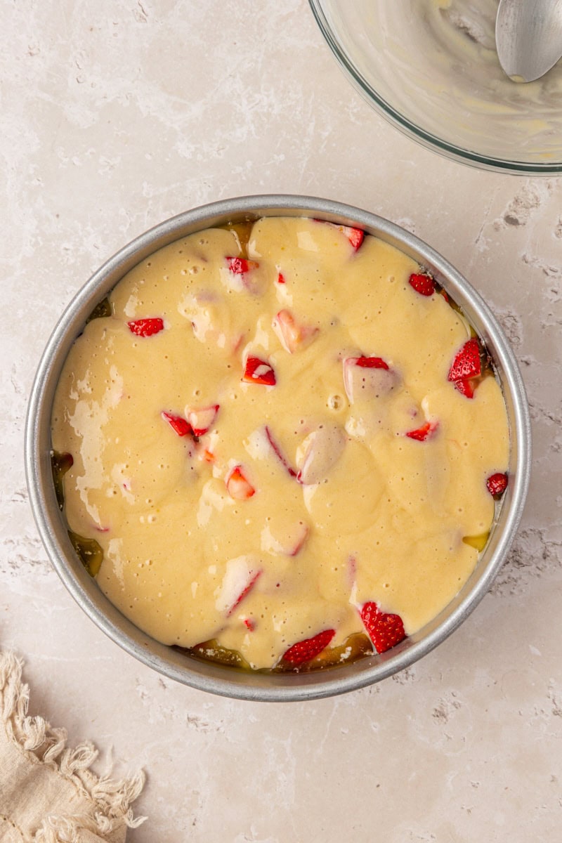 overhead view of strawberry spoon cake in a cake pan ready to go into the oven