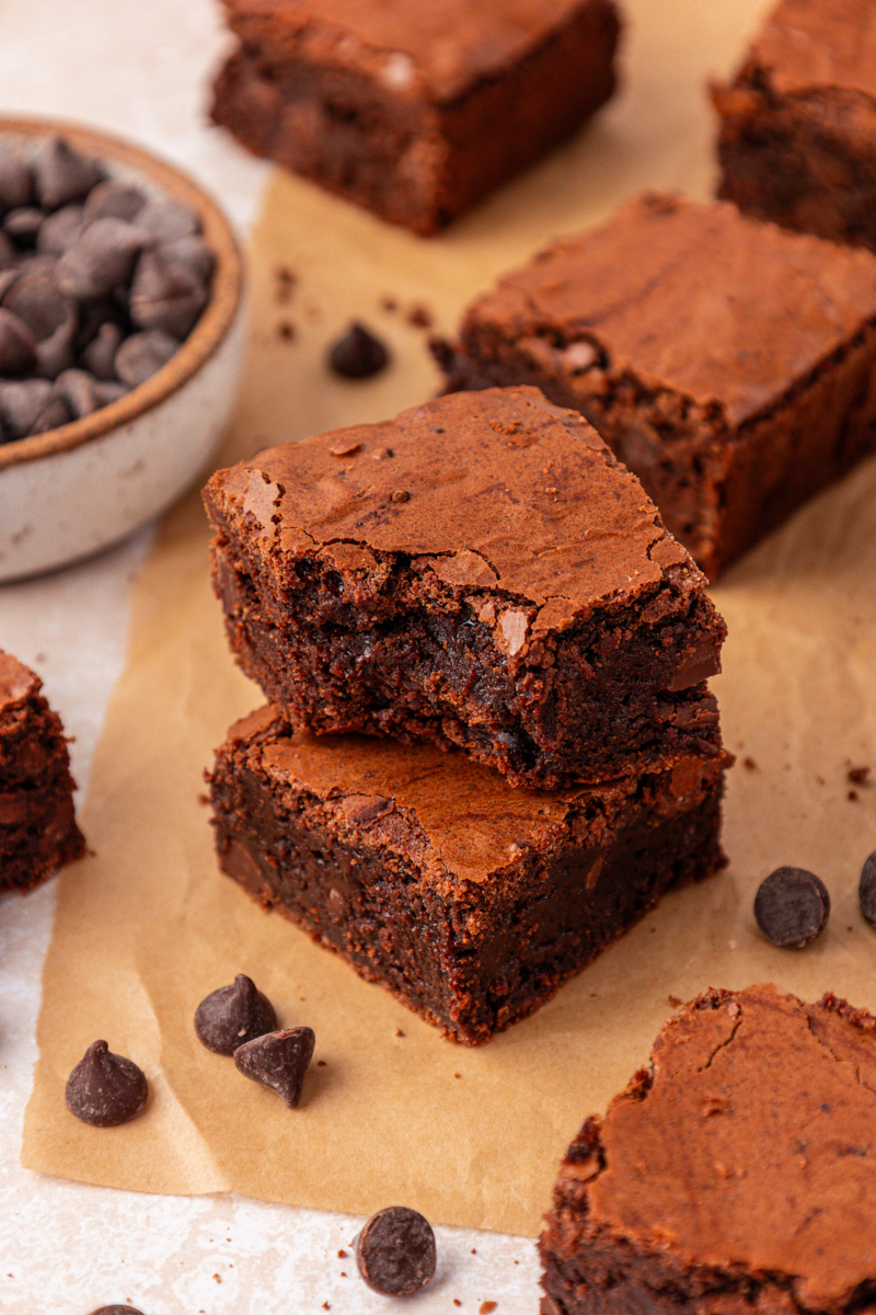 stack of two brown butter brownies with a bite missing from the top to show the fudgy interior