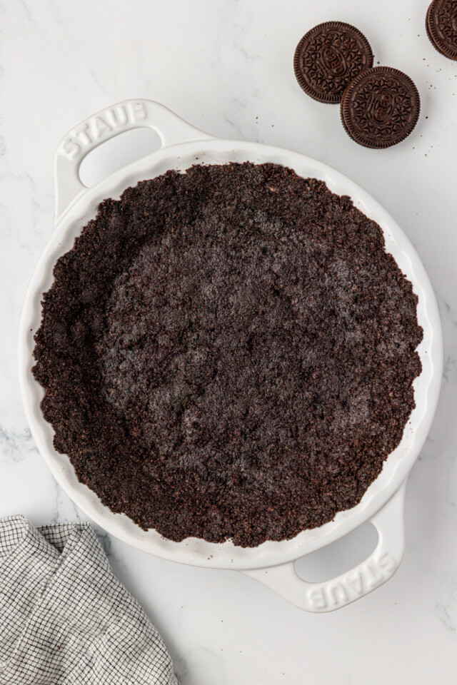 overhead view of Oreo cookie crust in a white pie pan