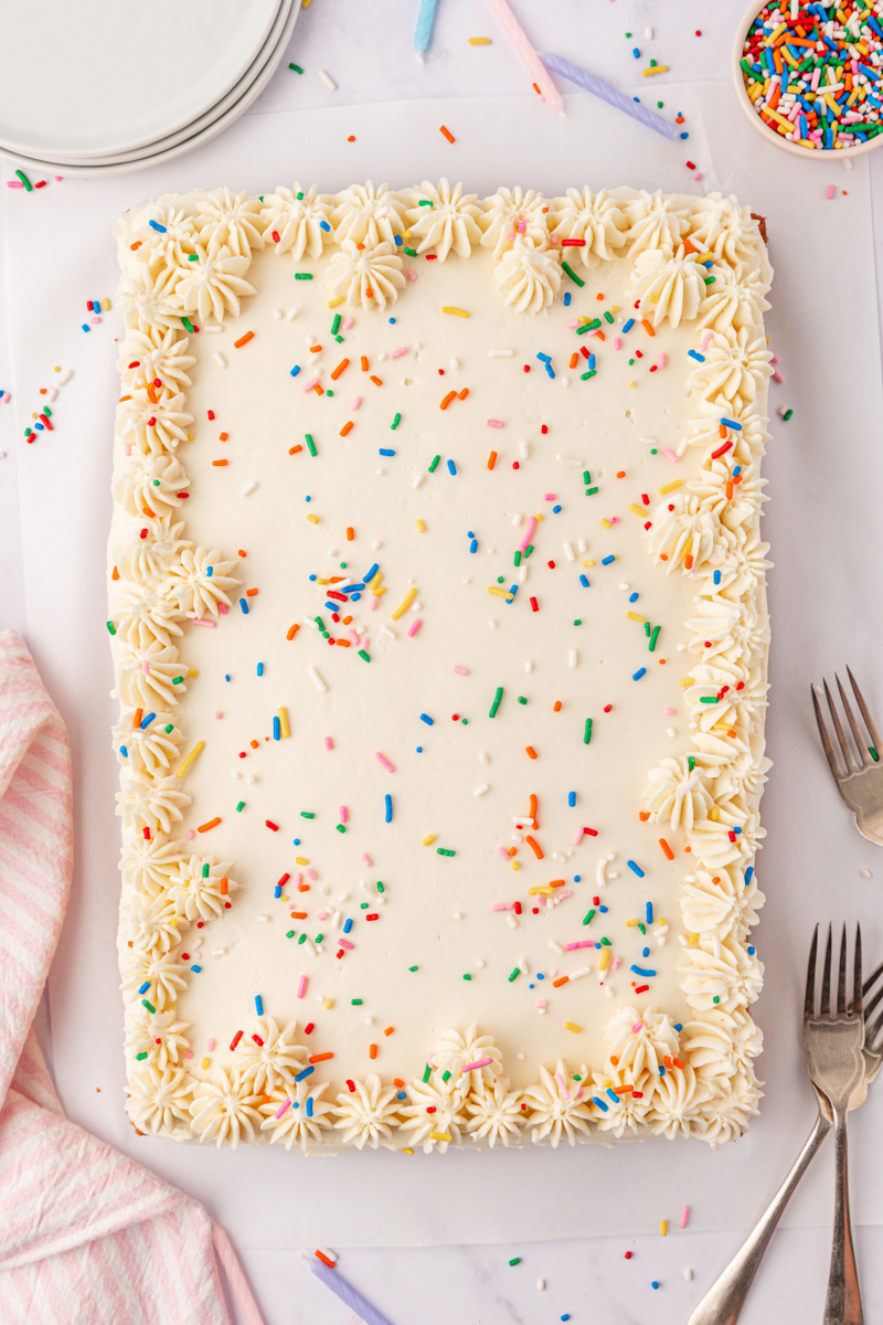 overhead view of frosted funfetti sheet cake decorated with more sprinkles