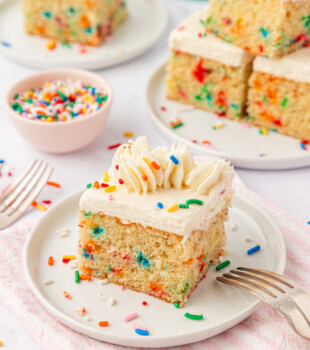 slice of funfetti sheet cake with vanilla frosting, filled and topped with rainbow sprinkles
