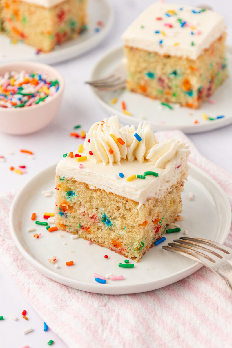 slice of funfetti sheet cake with vanilla frosting and lots of sprinkles