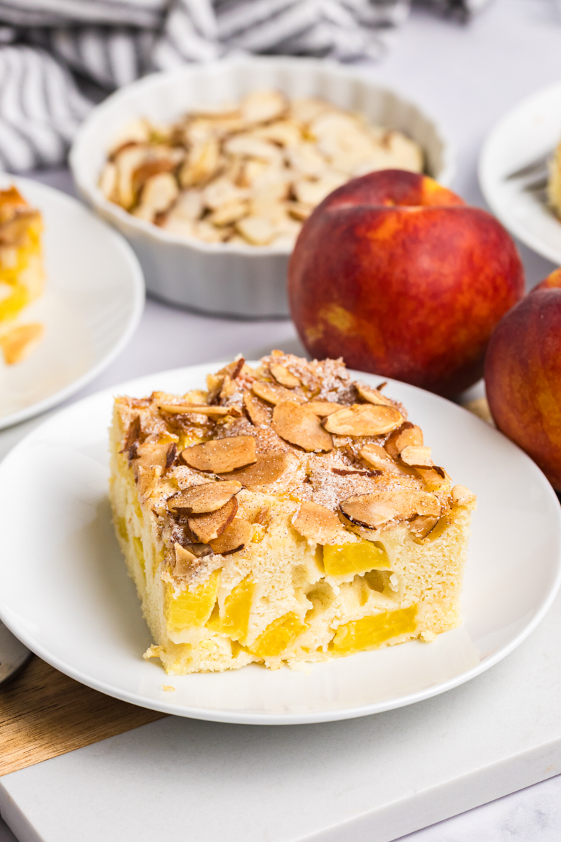 a slice of peach buckle made with fresh peaches and topped with a crunchy cinnamon-almond topping