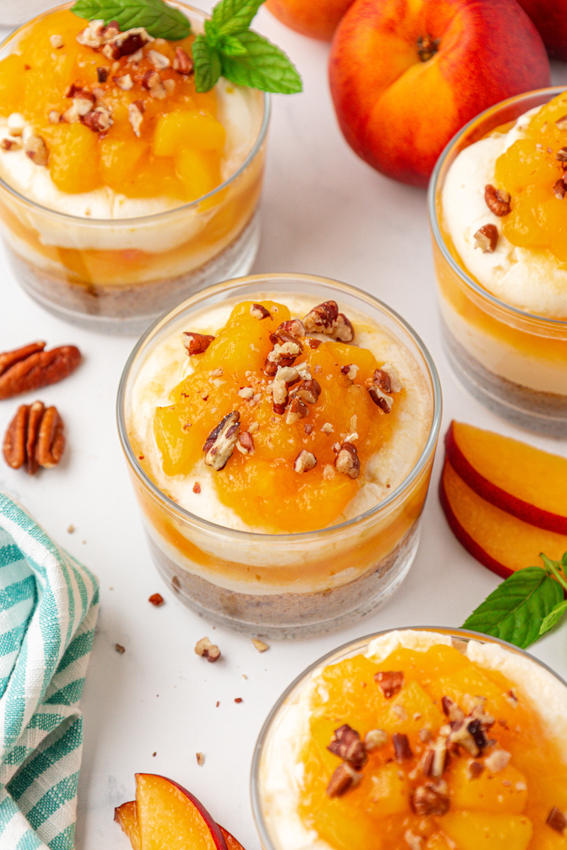 no-bake peach cheesecake jars garnished with toasted pecans