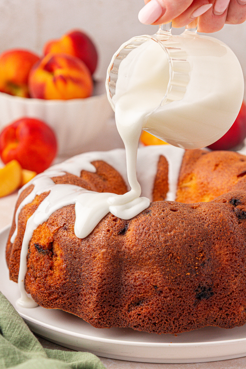 almond glaze pouring over peach pound cake