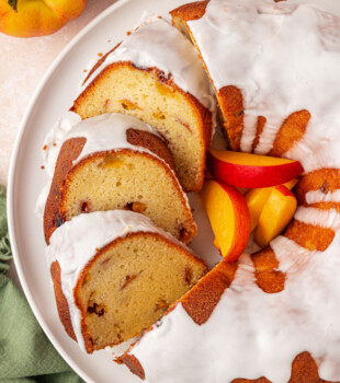 overhead view of partially sliced peach pound cake filled with fresh peaches and topped with an almond glaze