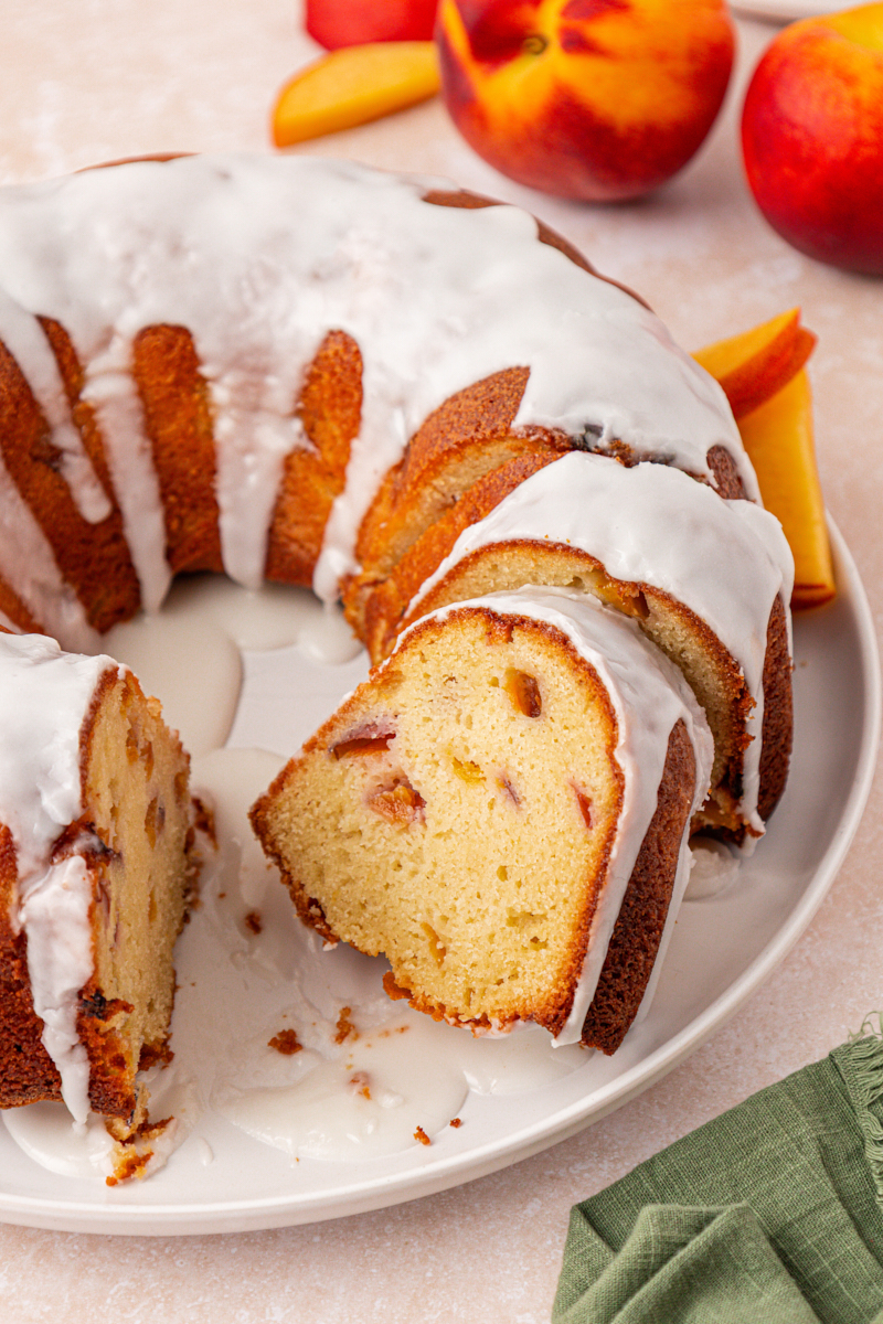 partially sliced peach pound cake topped with an almond glaze