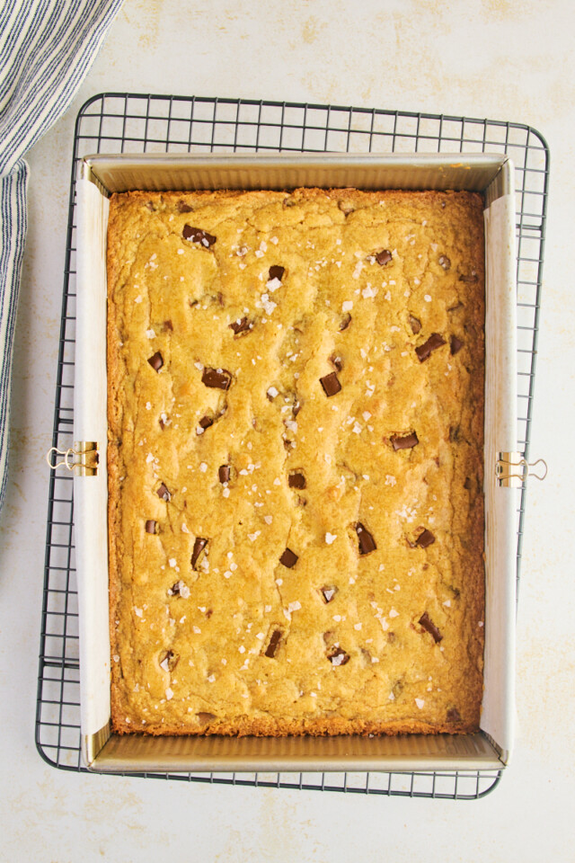 freshly baked chocolate chunk blondies in a 9x13 pan on a wire rack