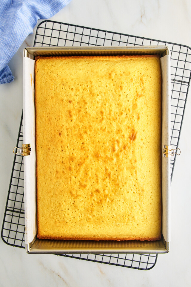 freshly baked vanilla cake in a 9x13 pan on a wire rack