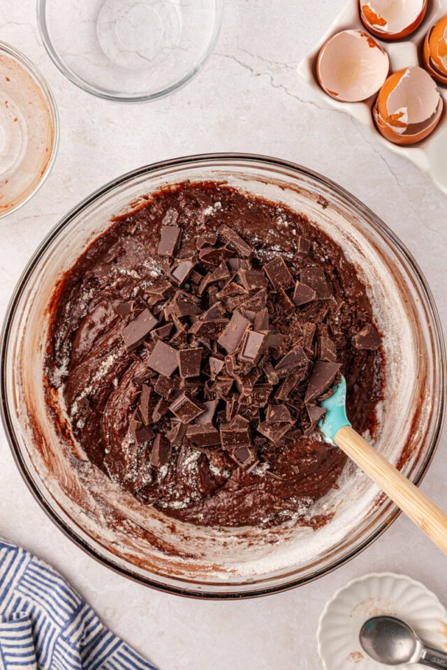 chopped chocolate added to brownie batter in a mixing bowl