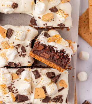 overhead view of s'mores brownies featuring graham crackers, chocolate, and marshmallows