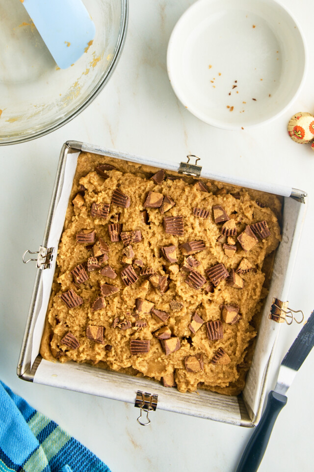 peanut butter cup blondies assembled in a square baking pan before baking