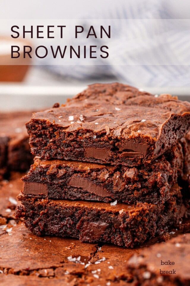 stack of three fudgy brownies filled with pieces of dark chocolate; text overlay "sheet pan brownies"