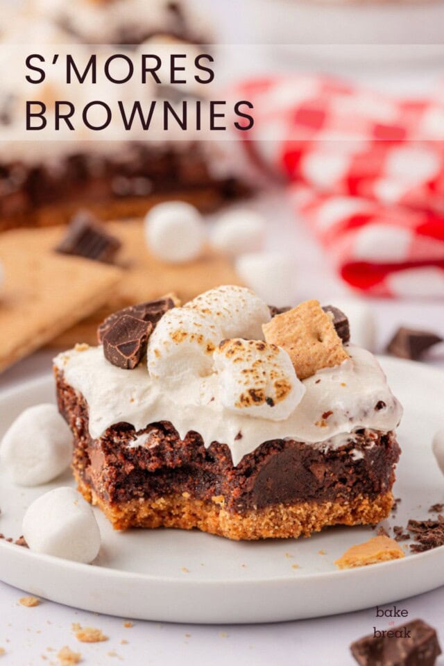 a fudgy brownie on top of a graham cracker crust and topped with marshmallow frosting, toasted marshmallows, chocolate, and graham cracker pieces; text overlay "s'mores brownies"