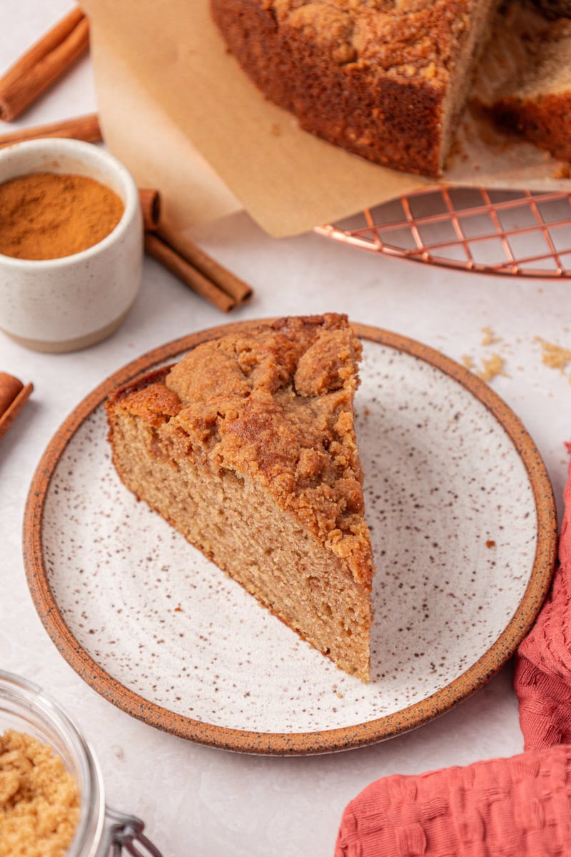 a slice of cinnamon cake with streusel layered through the middle and on top