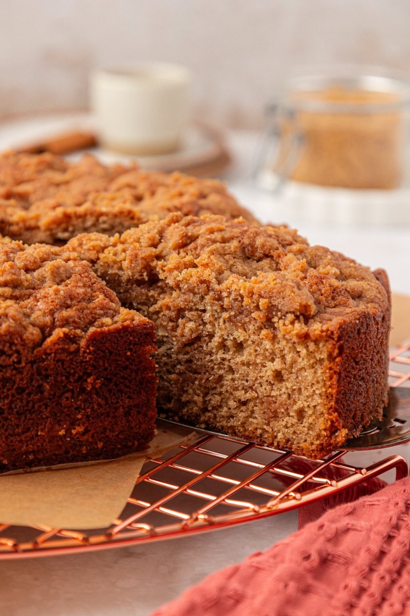 a slice of cinnamon streusel muffin cake on a cake server being removed from the remaining cake