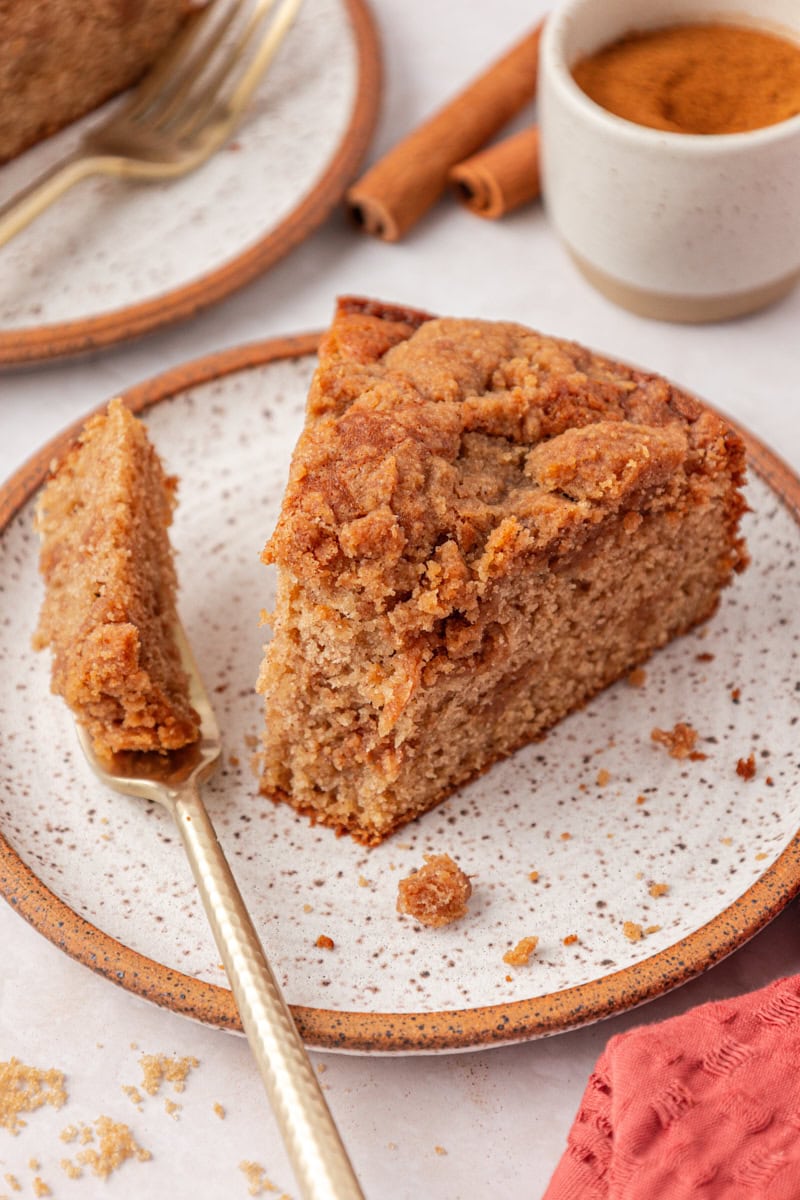 individual slice of cinnamon streusel coffee cake served on a plate with a bite on a fork