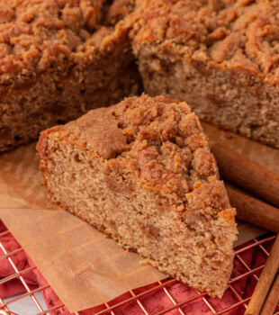 a slice of cinnamon streusel muffin cake alongside the remaining cake