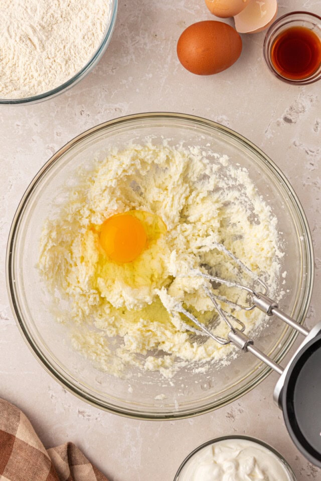 overhead view of egg added to creamed butter and sugar
