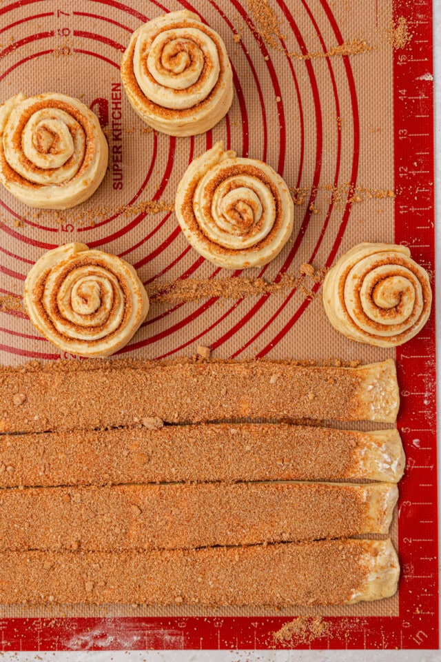 overhead view of cinnamon roll dough rolled into spirals with remaining dough cut and ready to roll