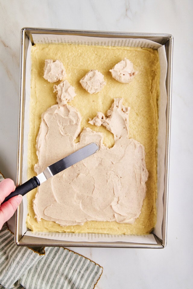cream cheese filling being spread over coffee cake batter