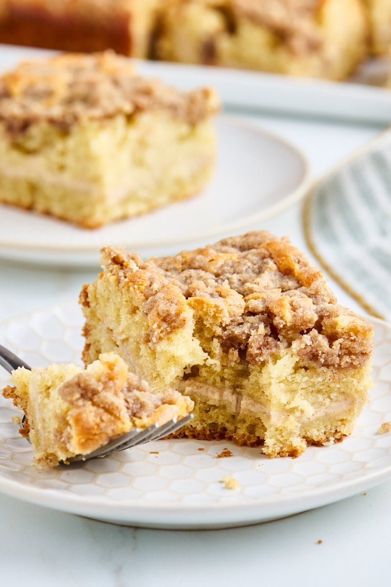 a slice of coffee cake with visible layer of cinnamon cream cheese filling and plenty of buttery crumb on top
