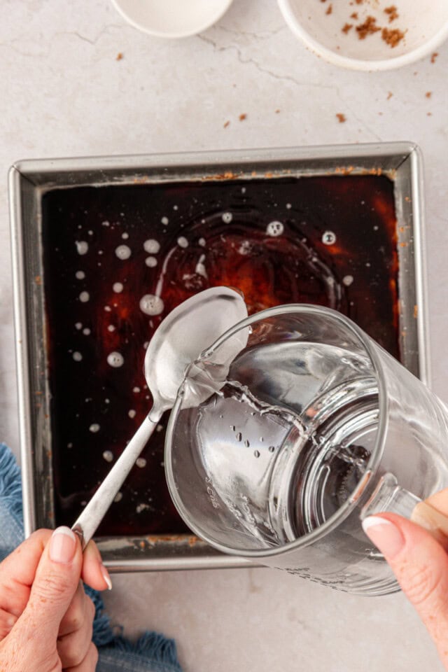 hot water poured over the back of a spoon onto cake batter in a square baking pan