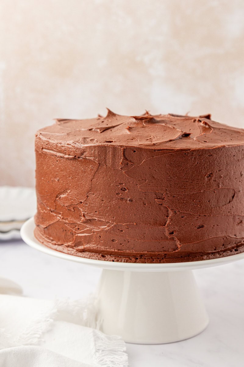 devil's food cake with chocolate buttercream on a white cake stand