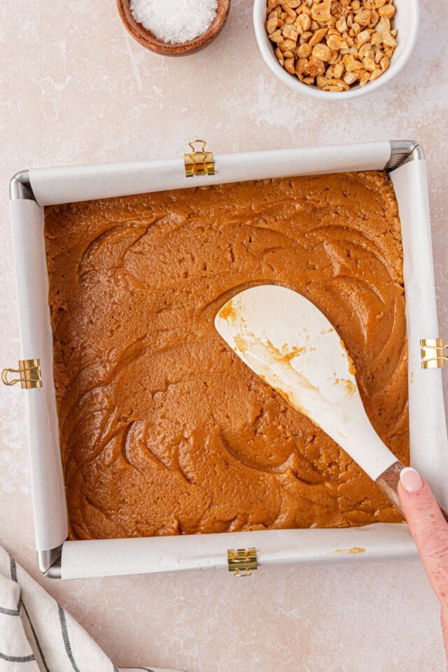 peanut butter blondies batter being spread in a square baking pan