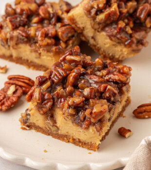 brown sugar cheesecake bar with a caramel-like pecan pie topping