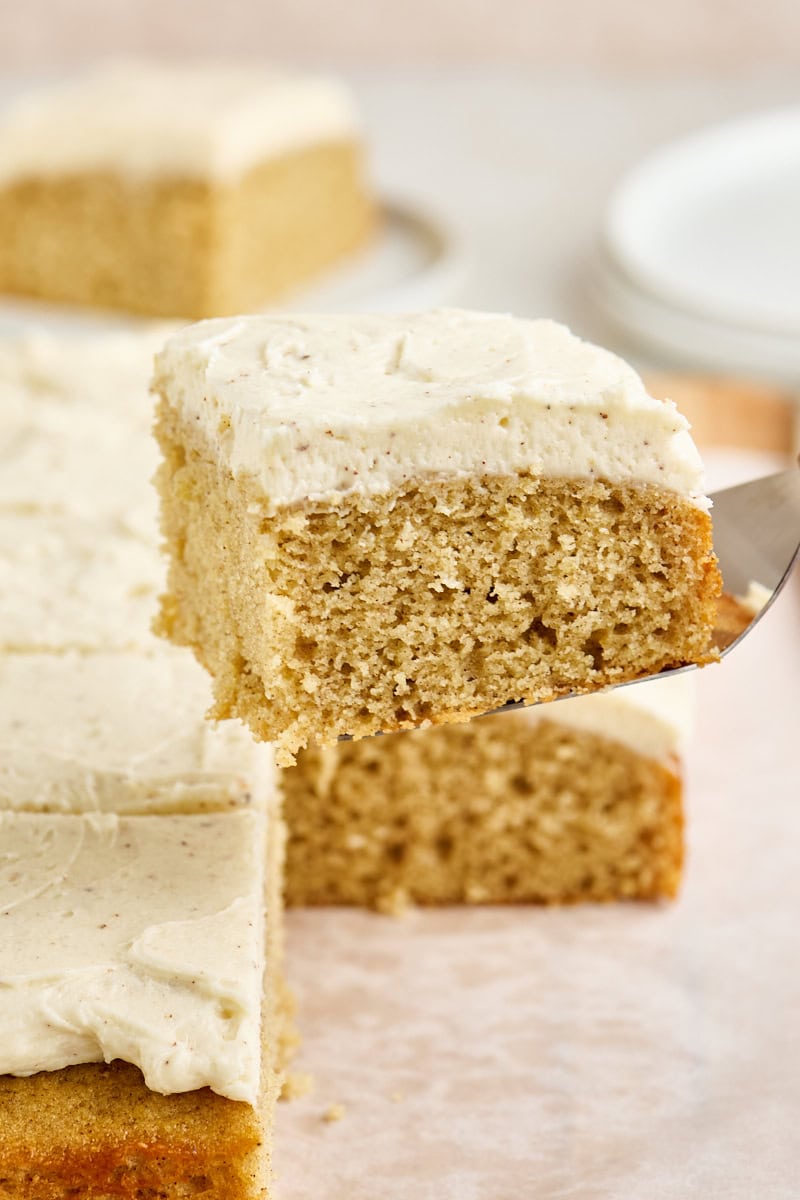 a slice of spice cake on a cake server lifting away from the remaining cake